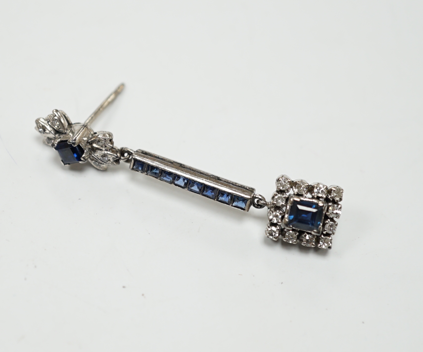 A single white metal (butterfly stamped 18), sapphire and diamond cluster set drop earring, 45mm, gross weight 4.1 grams.